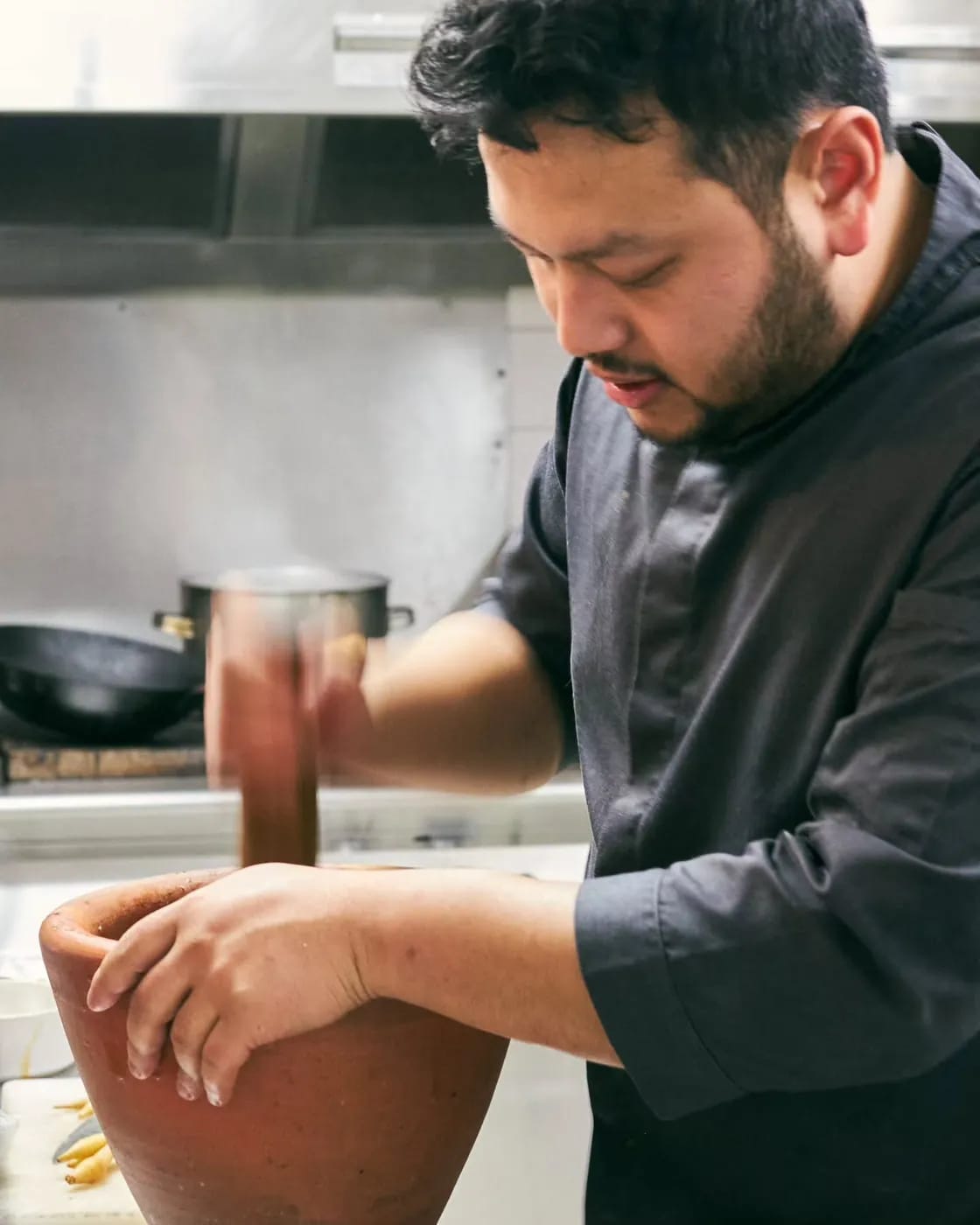 Le chef Thomas pile la pâte de curry au pilon et au mortier